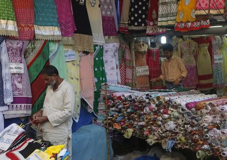 Vendors work as they wait for customers at a garment store in a market in Mumbai, India, February 4, 2016. REUTERS/Shailesh Andrade