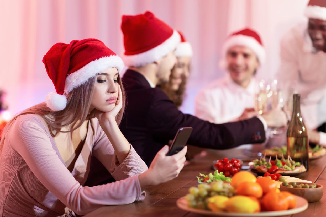 Woman bored at a Christmas party. (Getty Images)