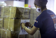 Dr. Abhu Kaur of Khalsa Aid USA, a global humanitarian organization, labels a pallet of electrical transformers, which will be shipped to New Delhi with oxygen concentrators this week on New York’s Long Island, Friday, May 7, 2021. With teams deployed in India to help support COVID-19 patients, Khalsa Aid USA plans to provide a total of 500 oxygen concentrators and 500 transformers to cities throughout the country. (AP Photo/Jessie Wardarski)