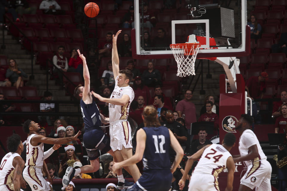 North Florida guard/forward Garrett Sams (11) makes a shot as he is fouled by Florida State center Balsa Koprivica (5) in the second half of an NCAA college basketball game in Tallahassee, Fla., Tuesday, Dec. 17, 2019. Florida State won 98-81. (AP Photo/Phil Sears)
