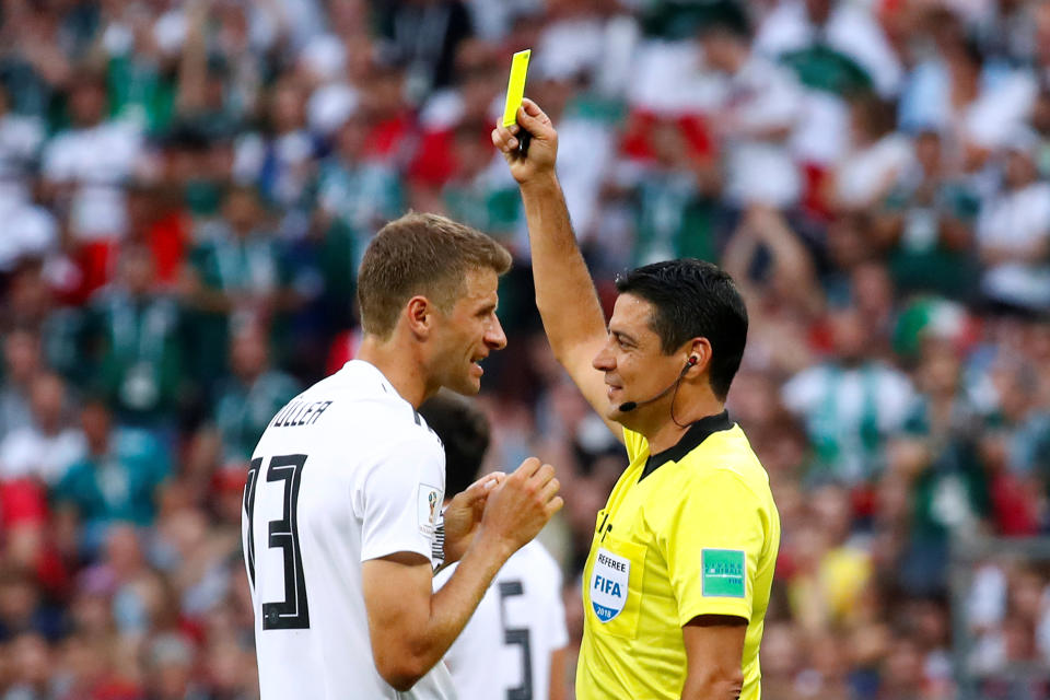 Germany's Thomas Muller is shown a yellow card by referee Alireza Faghani.