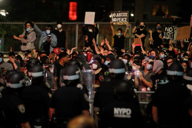 Oficiales de la policía de Nueva York se enfrentan a manifestantes después del toque de queda durante una protesta contra la muerte de George Floyd en la ciudad de Nueva York, EEUU