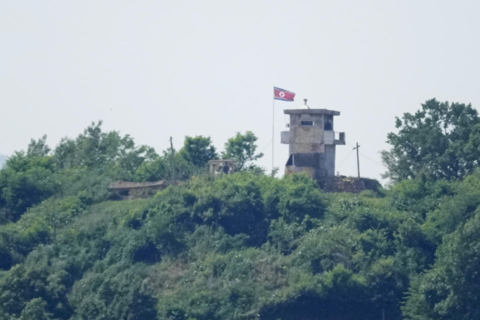 North Korean soldiers stand near their military guard post as a North Korean flag flutters in the wind, seen from Paju, South Korea, Sunday, June 9, 2024. South Korean soldiers fired warning shots after North Korean troops briefly violated the tense border earlier this week, South Korea's military said Tuesday, as the rivals are embroiled in Cold War-style campaigns like balloon launches and propaganda broadcasts. (AP Photo/Lee Jin-man)