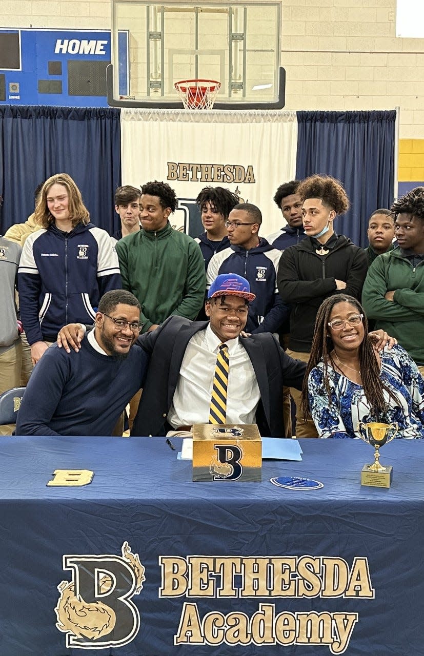 Jalil Calhoun of Bethesda, with his parents and teammates, as he signed to play football at Savannah State Wednesday.