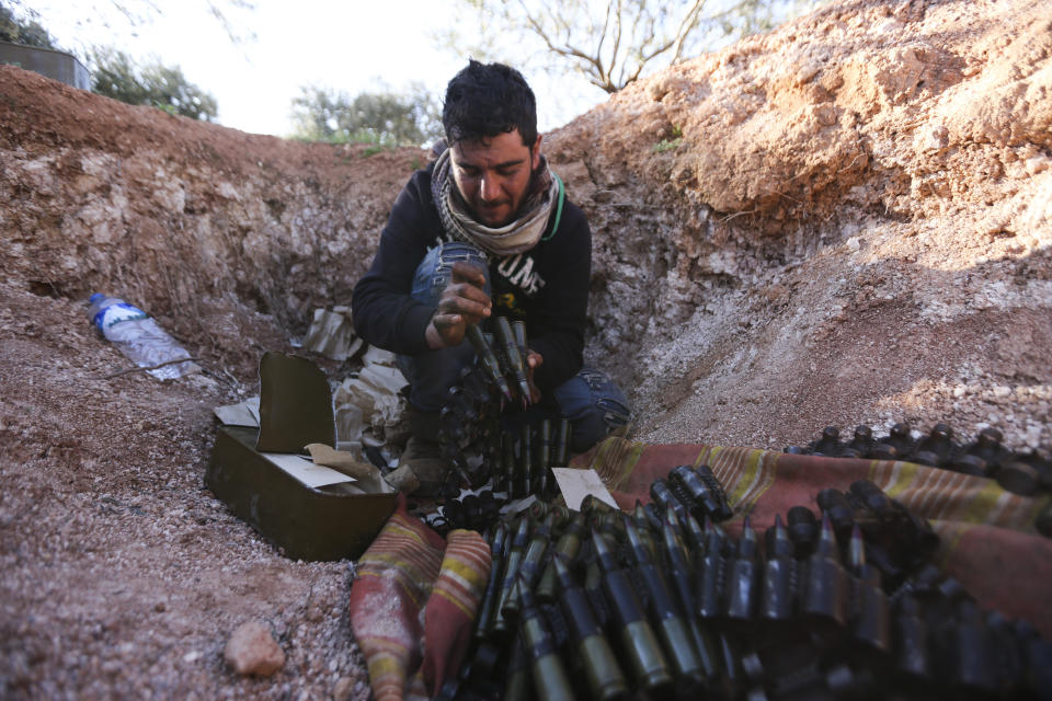 Turkish backed Syrian fighter loads ammunition at a frontline near the town of Saraqib in Idlib province, Syria, Wednesday, Feb. 26, 2020. Syrian government forces have captured dozens of villages, including major rebel strongholds, over the past few days in the last opposition-held area in the country's northwest. (AP Photo/Ghaith Alsayed)