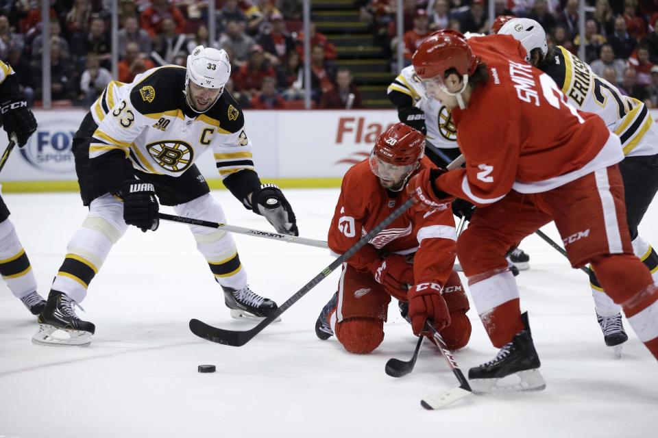 Detroit Red Wings defenseman Brendan Smith (2) controls the puck in front of teammate Drew Miller (20) and Boston Bruins defenseman Zdeno Chara (33) of the Czech Republic, during the second period of Game 3 of a first-round NHL hockey playoff series in Detroit, Tuesday, April 22, 2014. (AP Photo/Carlos Osorio)