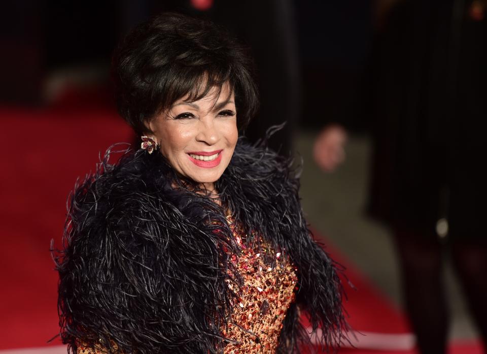 Dame Shirley Bassey poses on arrival for the world premiere of the new James Bond film 'Spectre' at the Royal Albert Hall in London on October 26, 2015. The film is directed by Sam Mendes and sees Daniel Craig play suave MI6 spy 007 for a fourth time.
 AFP PHOTO / LEON NEAL (Photo by LEON NEAL / AFP) (Photo by LEON NEAL/AFP via Getty Images)