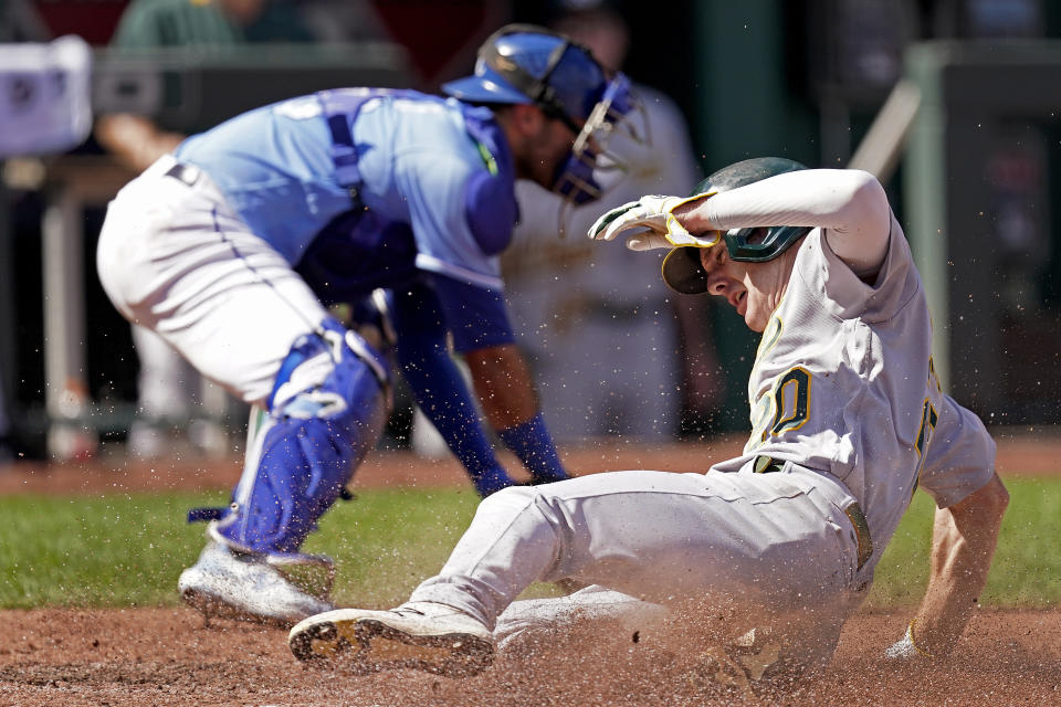 Oakland Athletics' Mark Canha slides home to score on a single by Chad Pinder during the third inning of a baseball game against the Kansas City Royals Thursday, Sept. 16, 2021, in Kansas City, Mo. (AP Photo/Charlie Riedel)