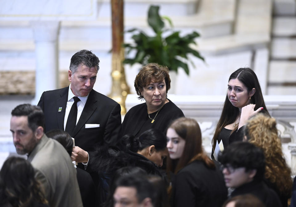 From left, Brian Fraser's father, Sean, mother, Mary 'Mia' and sister, Micaela, wait for Brian's casket to proceed into the church as family members friends and supporters gather during the funeral mass for Fraser at St Paul on the Lake Catholic Church, in Grosse Pointe Farms, Mich., Saturday, Feb. 18, 2023. Fraser was identified as one of three students slain during a mass shooting on Michigan State University's campus, Monday evening. (Todd McInturf/Detroit News via AP, Pool)
