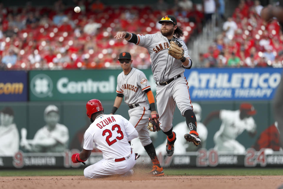St. Louis Cardinals' Marcell Ozuna (23) is out at second but San Francisco Giants shortstop Brandon Crawford, right, is unable to turn the double play while Giants second baseman Mauricio Dubon watches during the eighth inning of a baseball game Monday, Sept. 2, 2019, in St. Louis. Cardinals' Paul DeJong was safe at first. (AP Photo/Jeff Roberson)