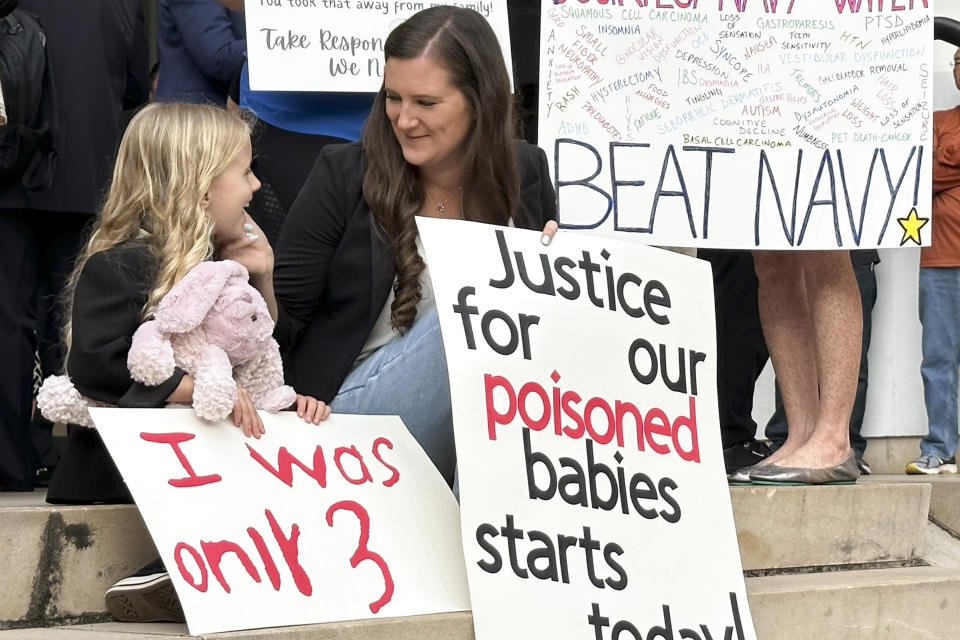 Plaintiffs in a trial for a mass environmental injury case hold signs outside the federal courthouse on Monday, April 29, 2024, in Honolulu. The trial is set to begin Monday more than two years after a U.S. military fuel tank facility under ground poisoned thousands of people when it leaked jet fuel into Pearl Harbor's drinking water. (AP Photo/Jennifer Kelleher)