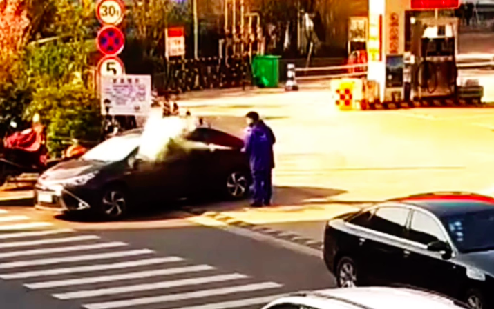 The worker sprays the extinguisher through the car window. Source: Newsflare