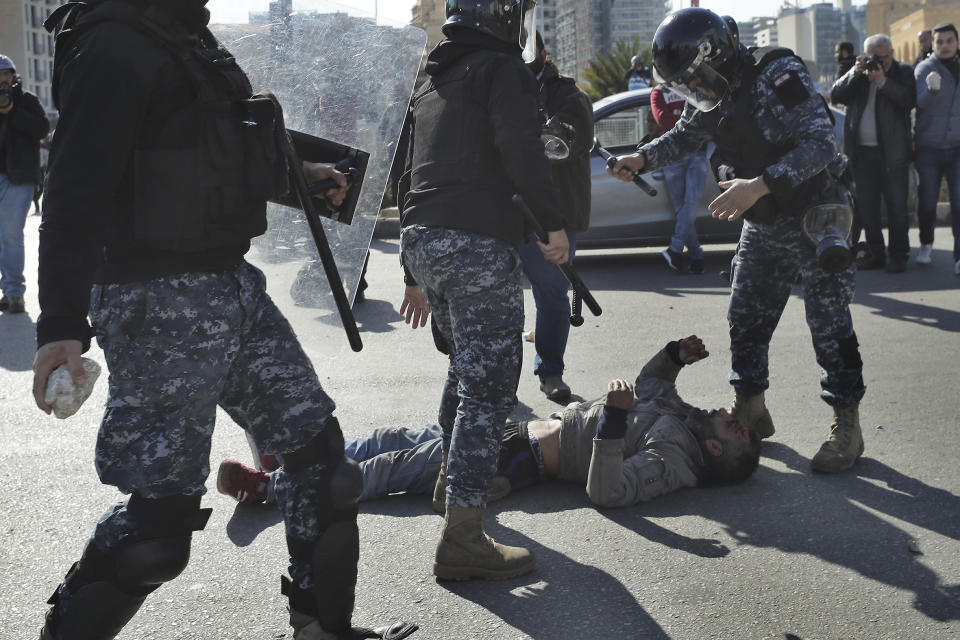 Police arrest an injured anti-government protester during scuffle on the road leading to the parliament building in downtown Beirut, Lebanon, Monday, Jan. 27, 2020. Lebanese security forces scuffled Monday with protesters near the parliament building in downtown Beirut where lawmakers are scheduled to begin a two-day discussion and later approval of the budget amid a crippling financial crisis. (AP Photo/Hassan Ammar)