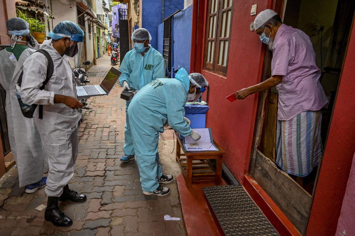 A resident prepares to register himself for receiving a dose of the COVID-19 vaccine during a mobile vaccination drive by army health officials in Colombo on Aug. 12, 2021.