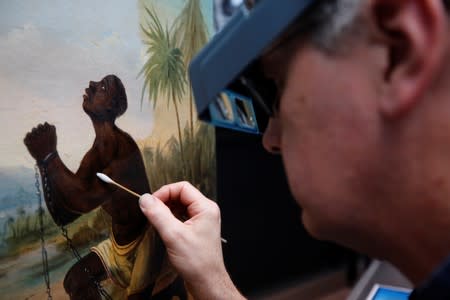 David Crombie, Senior Paintings Conservator at the National Museums, Liverpool carries out restoration work on the painting 'Am Not I A Man And A Brother', one of only 2 known paintings of its type in existence in Liverpool, Britain, July 30, 2019. Picture