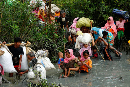 Rohingya refugees walk through water after crossing border by boat through the Naf River in Teknaf, Bangladesh, September 7, 2017. REUTERS/Mohammad Ponir Hossain