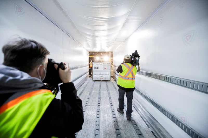 FOTO DE ARCHIVO: Miembros de los medios de comunicación fotografían mientras los empleados de FedEx cargan un envío desde Europa de la vacuna Moderna contra la enfermedad del coronavirus (COVID-19) en un camión de reparto refrigerado en el aeropuerto de Toronto Pearson, en Mississauga, Ontario, Canadá