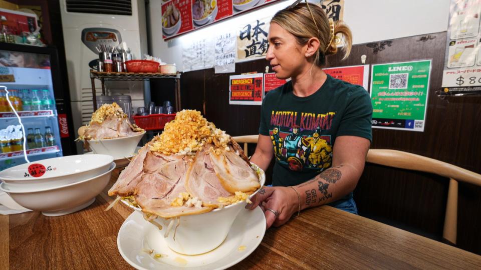 Katina DeJarnett with a giant bowl of ramen and a "mortal combat" t-shirt.