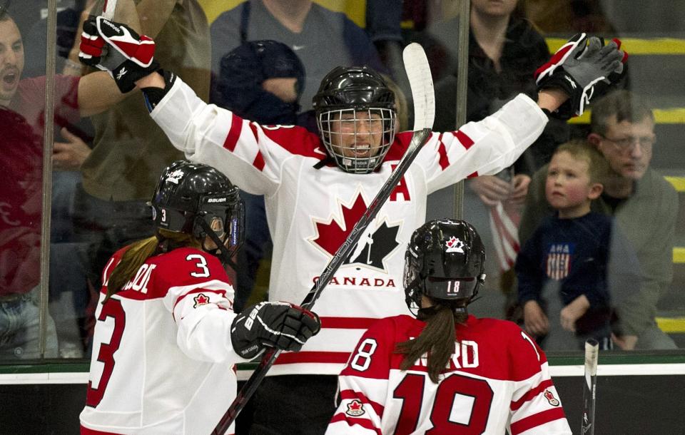 FILE - Canada's Caroline Ouellette celebrates her goal against the United States with teammates Jocelyne Larocque, left, and Catherine Ward during second-period gold medal hockey game action at the World Women's Ice Hockey Championships, Saturday, April 14, 2012, in Burlington, Vt. Ouellette is one of five players elected to the Hockey Hall of Fame, Wednesday, June 21, 2023. (Paul Chiasson, The Canadian Press via AP, File)