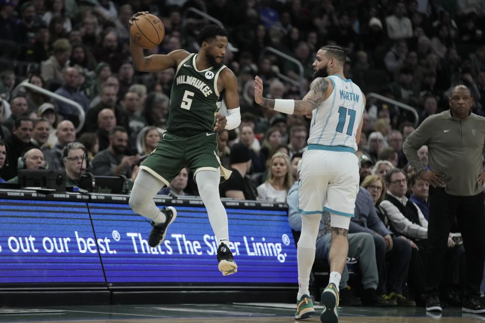Milwaukee Bucks' Malik Beasley tries to save the ball in front of Charlotte Hornets' Cody Martin during the second half of an NBA basketball game Friday, Feb. 9, 2024, in Milwaukee. (AP Photo/Morry Gash)