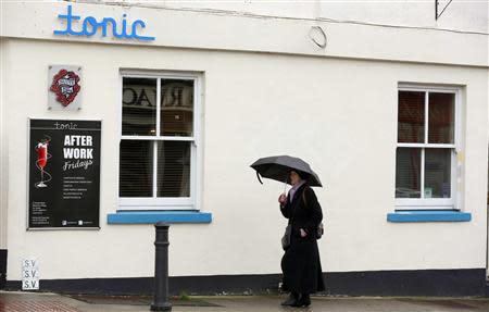 A woman walks past the 'tonic' bar and nightclub in the village of Blackrock, County Dublin, Ireland November 6, 2013. REUTERS/Cathal McNaughton