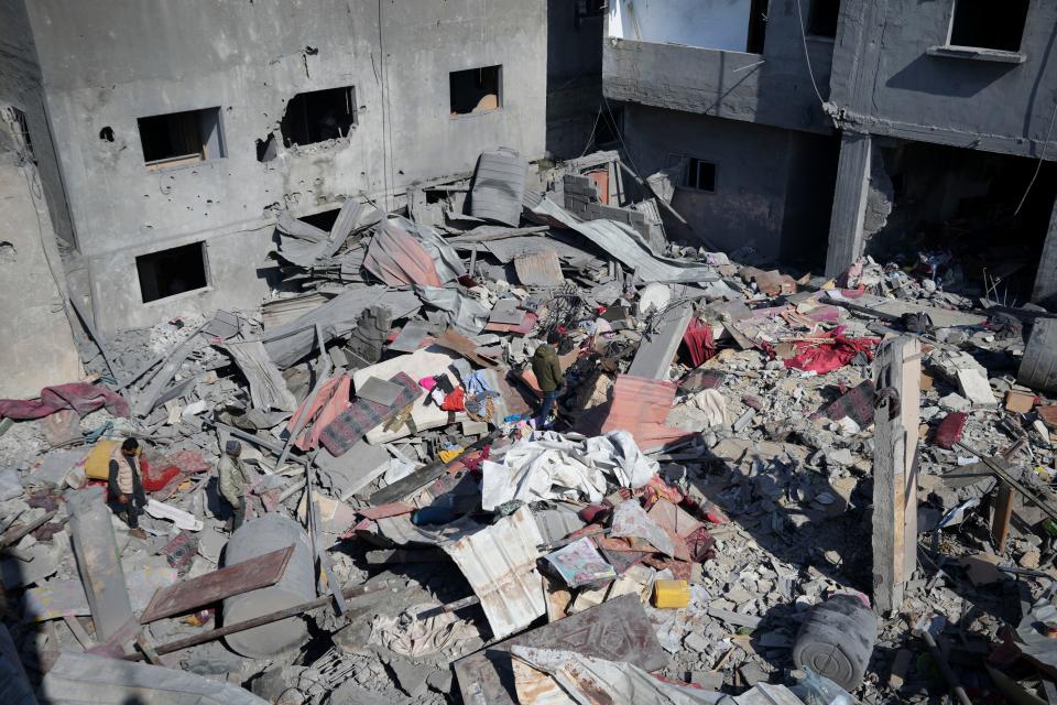 A Palestinian walks through the rubble of the Khatab family building after an Israeli airstrike in Deir al Balah, Gaza Strip, on Feb. 21, 2024.