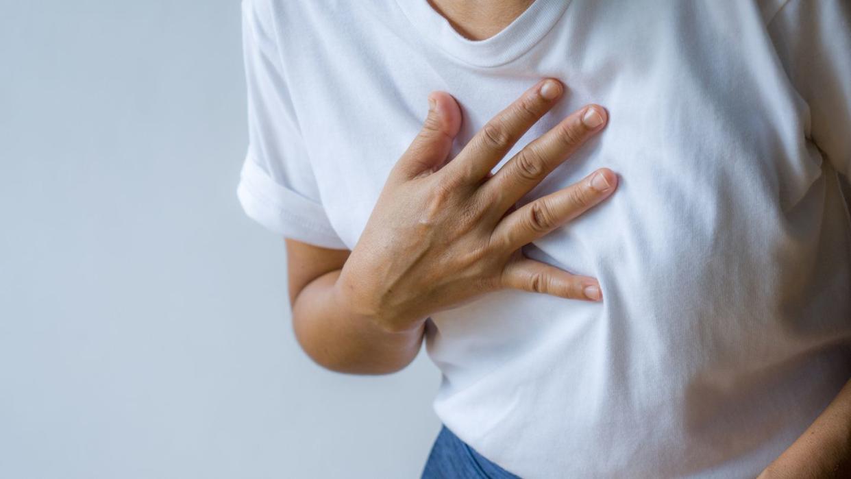 woman hand holding chest with symptom heart attack disease