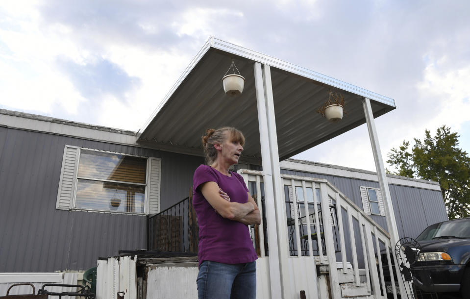 ADVANCE ON THURSDAY, SEPT. 12 FOR USE ANY TIME AFTER 3:01 A.M. SUNDAY SEPT 15 - In this Aug. 30th 2019 photo shows Karla Lyons, outside her mobile home at the Lamplighter Village in Federal Heights, Colo. Lyons' waitressing wages are eaten up by a constant stream of home and yard repairs ordered by her park manager, including removal of a giant maple tree that fell on her patio roof and crushed it. She would move if she could afford it. (Kathryn Scott/The Colorado Sun)