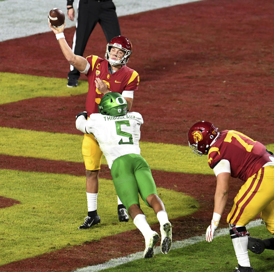 Oregon defensive end Kayvon Thibodeaux, 5, pressures USC quarterback Kedon Slovis in the first half of an NCAA college football game at the Los Angeles Memorial Coliseum in Los Angeles on Friday, Dec. 18, 2020. (Keith Birmingham/The Orange County Register via AP)