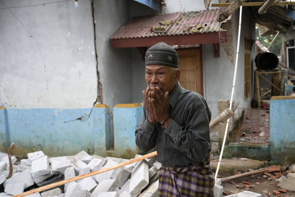 A man reacts as he inspects the damage caused by Monday's earthquake in Cianjur, West Java, Indonesia Tuesday, Nov. 22, 2022. The earthquake has toppled buildings on Indonesia's densely populated main island, killing a number of people and injuring hundreds. (AP Photo/Tatan Syuflana)