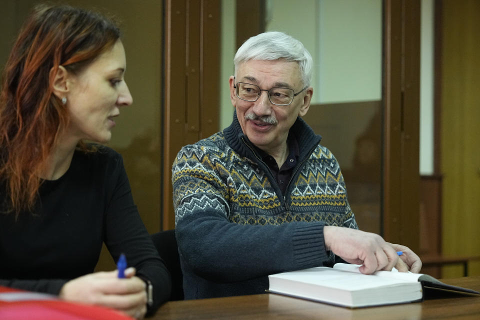 The co-chair of the Nobel Peace Prize winning Memorial Human Rights Centre Oleg Orlov, right, speaks to his lawyer prior to a court session for a new trial on charges of repeated discrediting Russian military, in Moscow, Russia, Monday, Feb. 26, 2024. (AP Photo/Alexander Zemlianichenko)