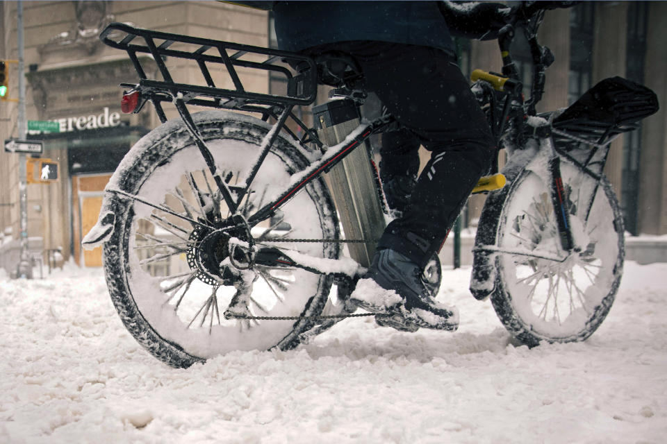 FILE - A bicycle food delivery worker rides his e-bike through heavy snow, Feb. 1, 2021, in the Soho neighborhood of New York. Lithium ion batteries used to power electric bicycles and scooters have already sparked 22 fires that caused 36 injuries and two deaths in New York City this year, four times the number of fires linked to the batteries by this time last year, city officials said Friday, Feb. 24, 2023. (AP Photo/Robert Bumsted, File)