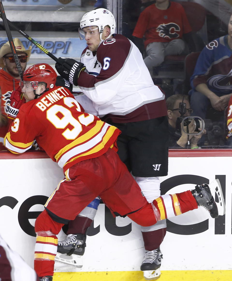 Colorado Avalanche defenseman Erik Johnson (6) takes a hit from Calgary Flames center Sam Bennett (93) during second period of Game 5 of an NHL hockey first-round playoff series Friday, April 19, 2019, in Calgary, Alberta. (Larry MacDougal/The Canadian Press via AP)