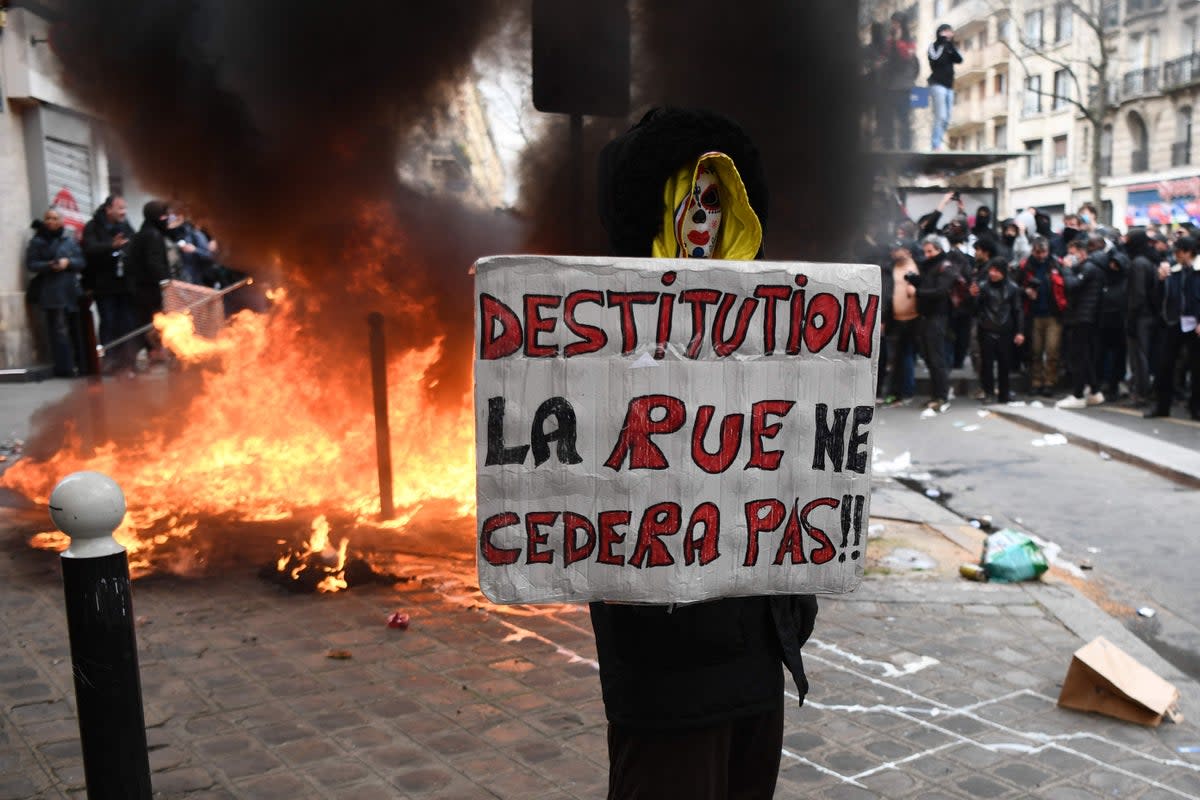 A demonstrator holds a placard reading ‘Impeachment. The street won’t give up’ during a rally in Paris (AFP via Getty Images)