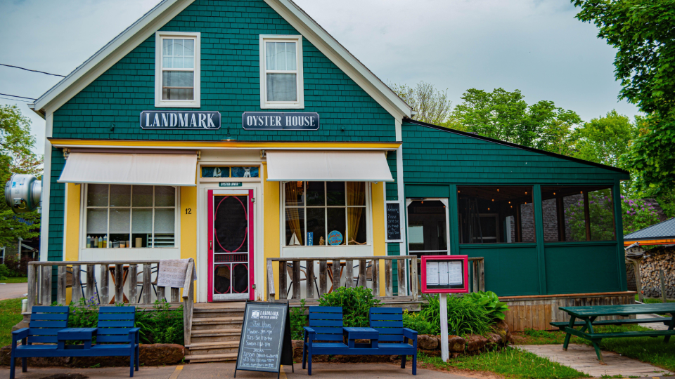 The Landmark Oyster House in Victoria, a green-painted building with outdoor seating