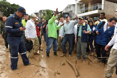 Colombia's President Juan Manuel Santos (4th R) gestures while visiting a flooded area after heavy rains caused several rivers to overflow, pushing sediment and rocks into buildings and roads in Mocoa, Colombia April 1, 2017. Cesar Carrion/Colombian Presidency/Handout via Reuters