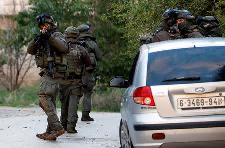 Members of Israeli armed forces aim their weapons during a raid in the West Bank city of Jenin, January 18, 2018. REUTERS/Mohamad Torokman