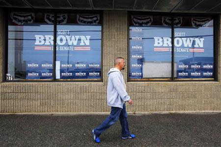 A pedestrian walks past the campaign offices for Republican candidate for the U.S. Senate Scott Brown in Manchester, New Hampshire May 10, 2014. REUTERS/Brian Snyder