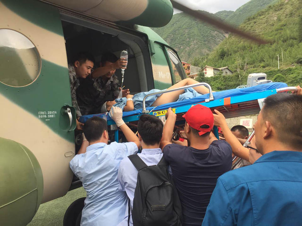 <p>Rescuers transfer a survivor, injured during an earthquake, by a helicopter to Sichuan Provincial People’s Hospital in Jiuzhaigou in China’s southwestern Sichuan province on Aug. 9, 2017. (Photo: STR/AFP/Getty Images) </p>