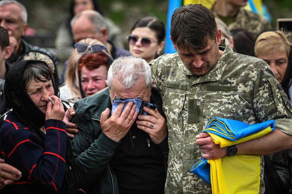 Relatives and friends of Ukrainian serviceman Volodymyr Nestor, killed in combat with Russian troops, mourn during his funeral at a cemetery in Lviv on Tuesday.