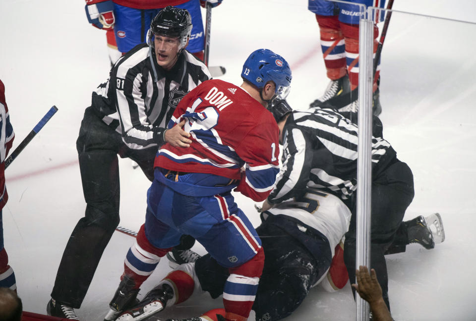 Montreal Canadiens' Max Domi is pulled away by linesman Ryan Daisy after a brief fight with Florida Panthers' Aaron Ekblad during the third period of an NHL hockey preseason game Wednesday, Sept. 19, 2018, in Montreal. (Paul Chiasson/The Canadian Press via AP)