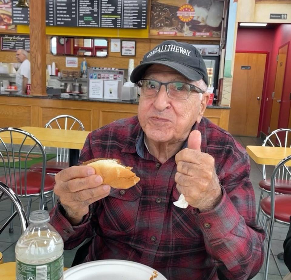 86 year-old Harry Baram enjoys a hot dog at Johnny & Hanges.