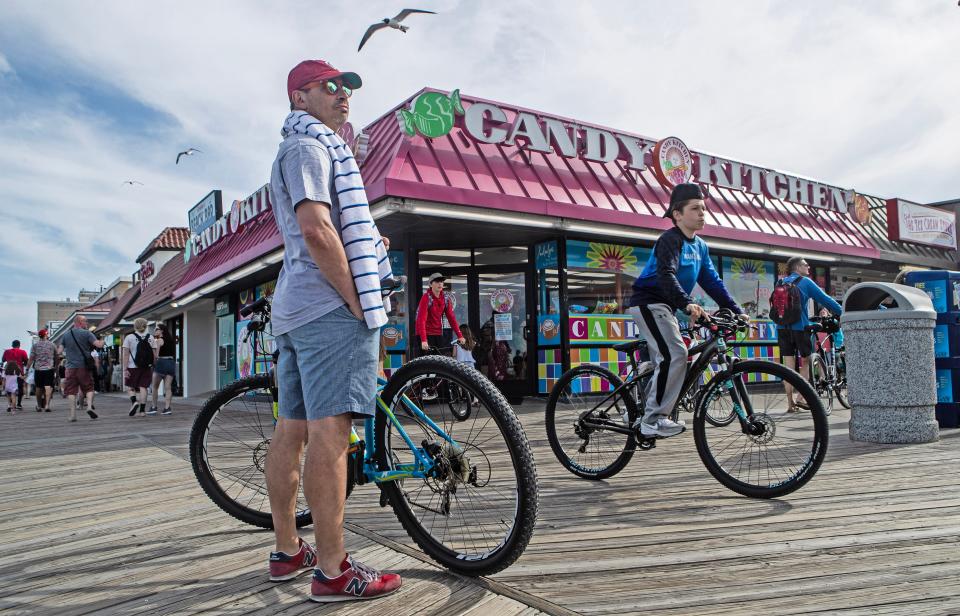 Visitors and residents ride bikes and stroll on the boardwalk outside Candy Kitchen on day 1 of the Memorial Day Weekend at Rehoboth Beach on Saturday, May 27, 2023.