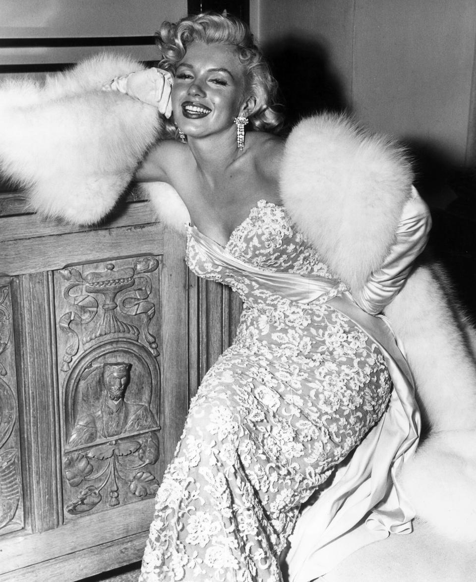 Marilyn Monroe (1926 - 1962) smiling as she sits at the home of director Jean Negulesco, after the premiere of his film, 'How to Marry a Millionaire,' in which she starred