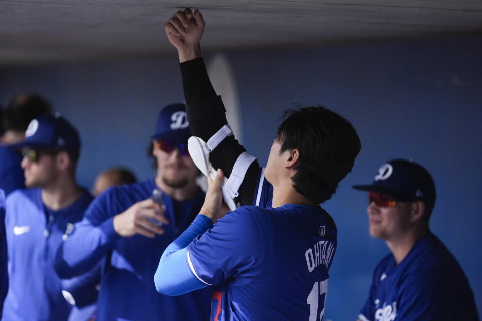 Los Angeles Dodgers designated hitter Shohei Ohtani prepares in the dugout before a spring training baseball game against the Chicago White Sox in Phoenix, Tuesday, Feb. 27, 2024. (AP Photo/Ashley Landis)