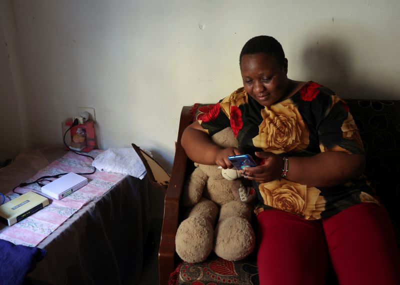 Kenyan migrant worker, Noel Musanga, uses her mobile phone during an interview with Reuters, in her apartment in Burj Hammoud