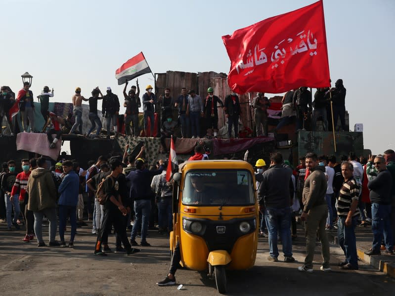 Demonstrators gesture as they take part in the ongoing anti-government protests at Ahrar bridge in Baghdad