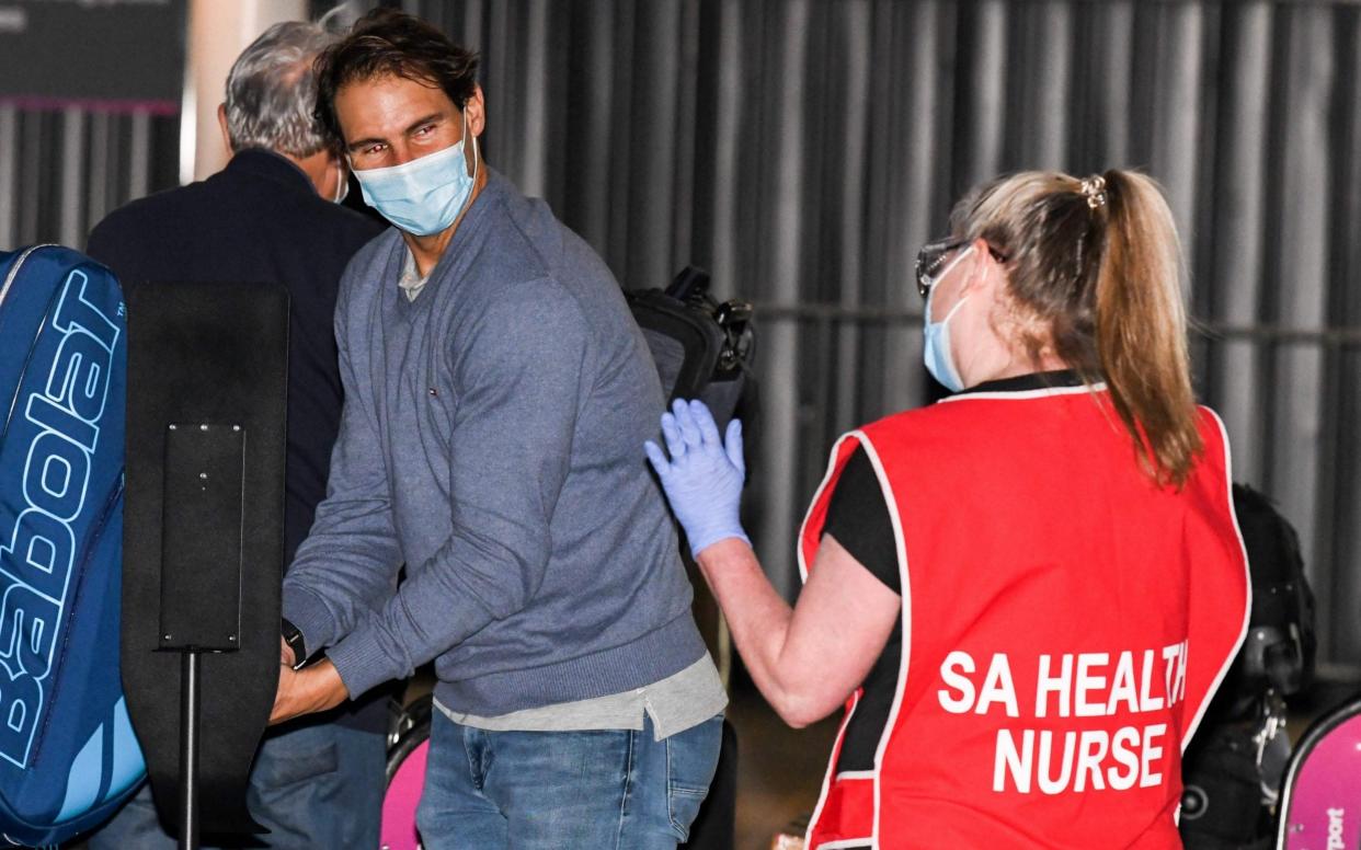 Spanish tennis player Rafael Nadal gets a wave from a nurse as he arrives before heading straight to quarantine for two weeks isolation ahead of their Australian Open warm up matches in Adelaide on January 14, 2021. - AFP/BRENTON EDWARDS 