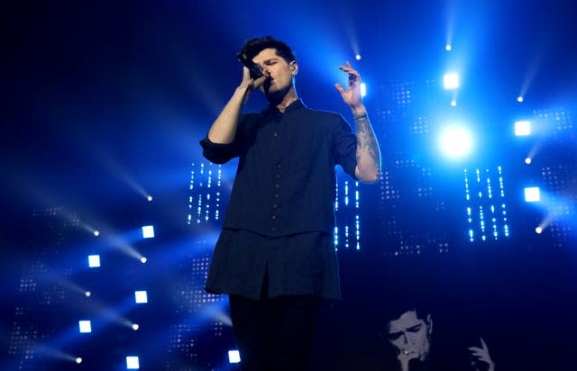 Danny O'Donoghue performing on stage in a blue shirt