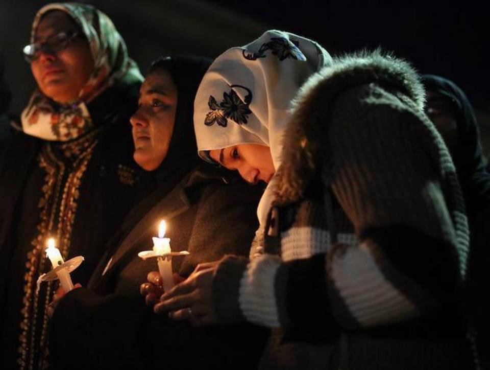 Suzanne Askar, from Cary, rests her head on the shoulder of Safam Mahate, a student at North Carolina State University, as they stand next to Nida Allam, far left, also a student at North Carolina State University, during a candlelight vigil on the campus of the University of North Carolina at Chapel Hill for the three Muslim students killed yesterday in Chapel Hill.